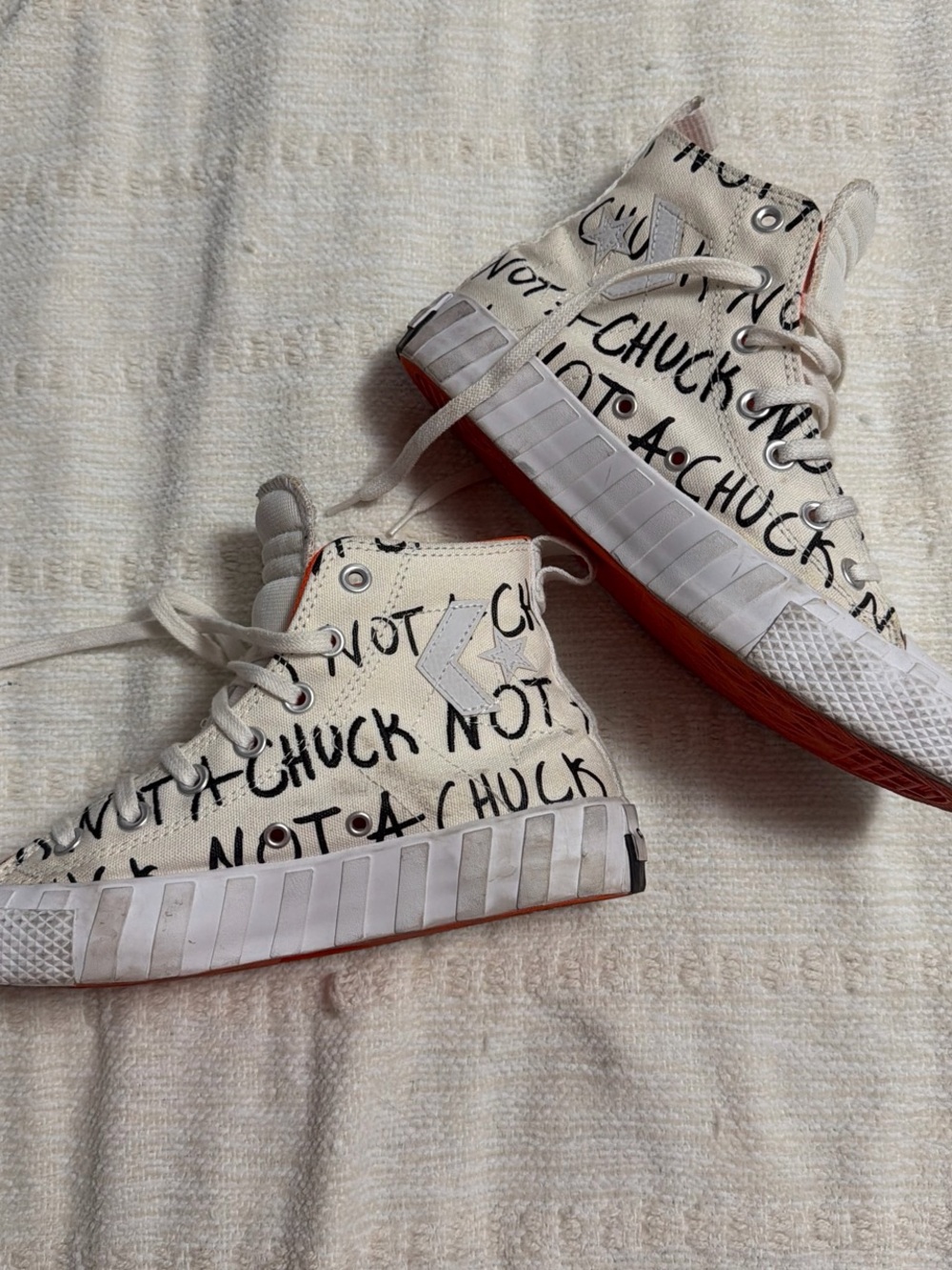 Converse High Top Sneakers in White with Red Sole and Black Graphic Text